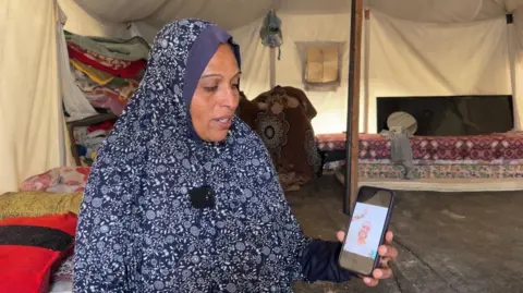 BBC Lina al-Dabah shows photo of her dead daughter Aya on a mobile phone