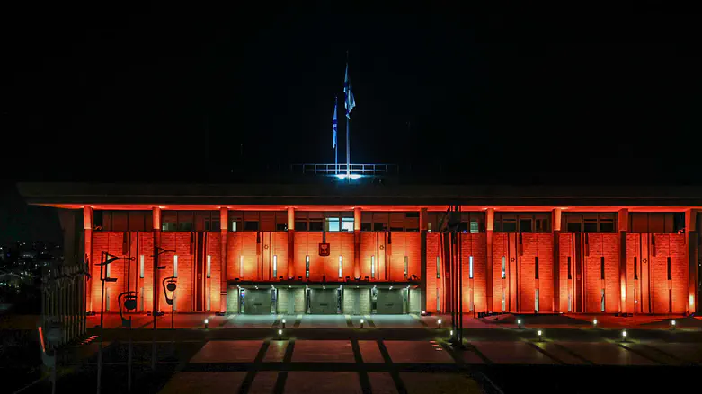 Knesset building lit up in orange ahead of funeral for Shiri, Ariel and Kfir Bibas