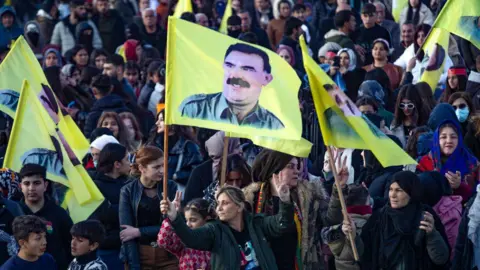 Getty Images A crowd of people, some holding yellow flags bearing pictures of PKK founder Abdullah Ocalan